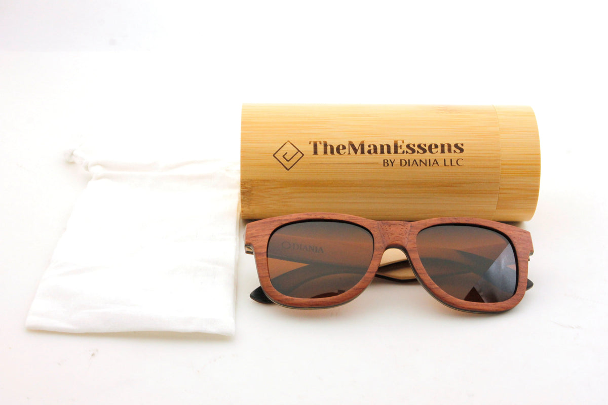Els Plans bubinga Skateboard Wood Sunglasses next to cotton bag and in front of bamboo cilinder case