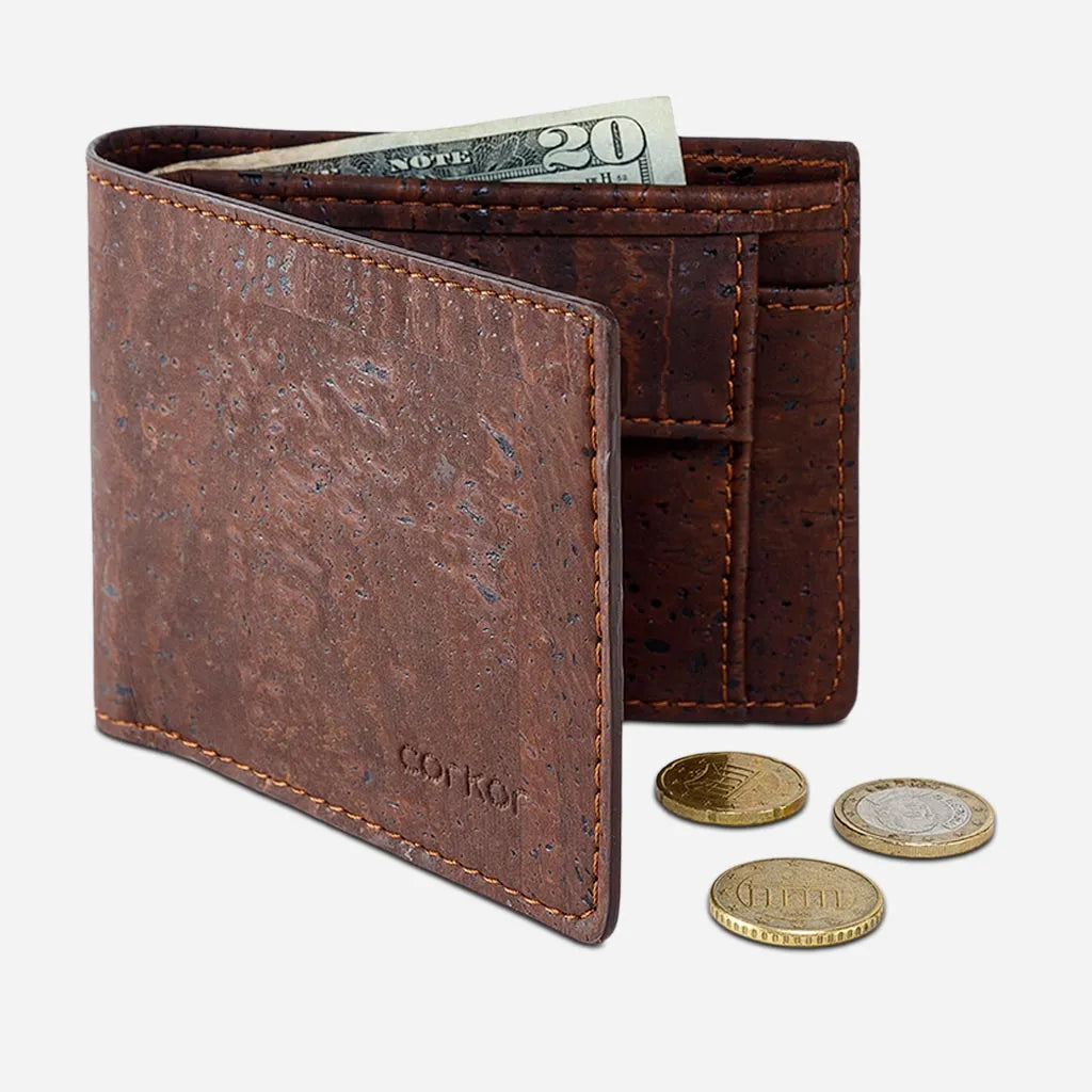 Brown cork coin wallet standing open with coins beside it