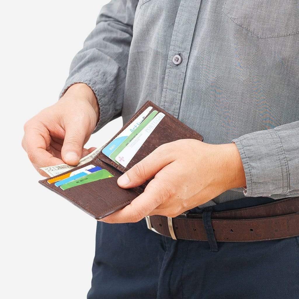Man opening the brown slim cork bifold wallet to take out a card