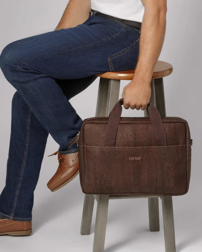 Man sitting on a stool holding a Cork Briefcase - 14"
