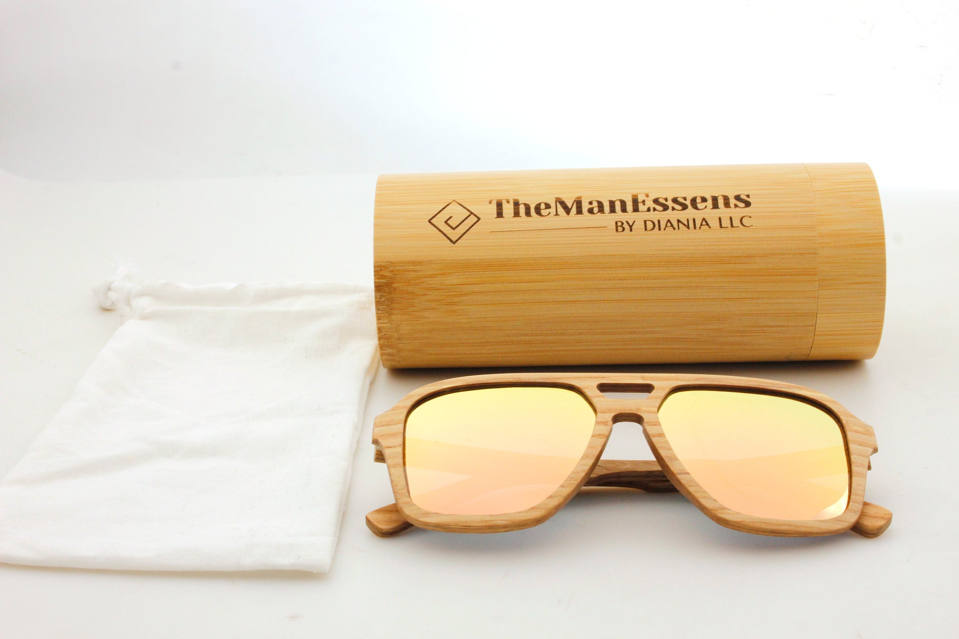 Bèrnia layered oak wood sunglasses next to cotton bag and in front of bamboo cilinder case
