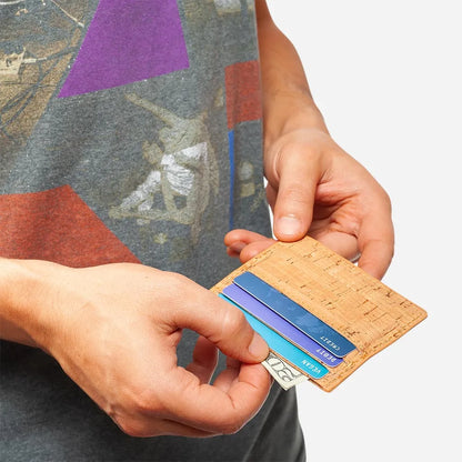 Front Side of The vegan card holder wallet, Light Brown Cork. Hand taking out a 20 dollar bill from the central pocket.