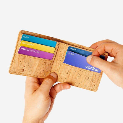 Hand taking out a card from one of the card slots on the Bifold Wallet for Men. Light Brown Cork.